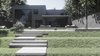 Modern home with Outdoor, Shrubs, Landscape Lighting, Grass, Back Yard, Horizontal Fences, Wall, and Vertical Fences, Wall. Back facade of the house says more.
This giant window from ceiling to floor and almost in full width of the house, is responsible for the second light planning inside. Photo 11 of The Grey House