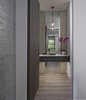 Modern home with Bath Room, One Piece Toilet, Engineered Quartz Counter, Pendant Lighting, Vessel Sink, Porcelain Tile Wall, Ceiling Lighting, and Light Hardwood Floor. Powder Room Photo 8 of Contemporary Michigan Lake Home