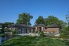Completed in 2017, this home in Franklin, inspired by the Frank Lloyd Wright Robie House in Chicago features large overhangs and a shallow sloped hip roof. The exterior features long pieces of Indiana split-faced limestone in varying heights and elongated norman brick with horizontal raked joints and vertical flush joints to further emphasize the linear theme. The courtyard features a combination of exposed aggregate and saw-cut concrete while the entry steps are porcelain tile. The siding and fascia are wire-brushed African mahogany with a smooth mahogany reveal between boards.
Photo 17 of Contemporary Michigan Lake Home modern home