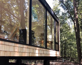 The retreat's exterior is clad in cedar shingles to give it a tree house feel. The shingles will weather to gray over time. Dutton wanted to avoid having the cabin stand out, instead revealing itself gradually against the surrounding landscape.