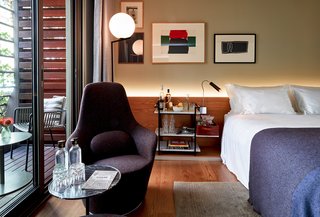 Sir Victor’s rooms and suites were conceived by Sir Hotels’ in-house design team. This bedroom pairs a Harbor chair by B&B Italia with handmade rugs by Nani Marquina and paintings by local artist Bernat Daviu.