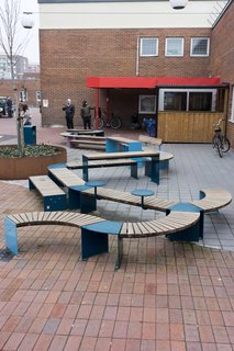 Biblioteksplatsen introduces color, light, and life to the local library via a sweeping bench, a living wall, tables and seats, and hanging lanterns.