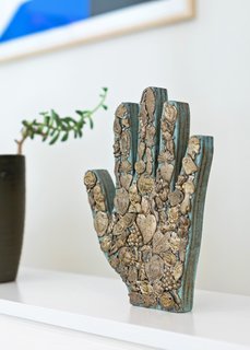 A blue hand Finlayson found in San Miguel de Allende has popped up in several of her paintings—and her logo. 