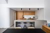 Modern home with Kitchen, Range, Undermount Sink, Wood Cabinet, Ceiling Lighting, Porcelain Tile Floor, Ceramic Tile Backsplashe, Engineered Quartz Counter, Recessed Lighting, and Refrigerator. Kitchen and Dining - After Photo 10 of Throckmorton Renovation