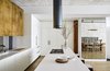 Modern home with Kitchen, Dishwasher, Refrigerator, Cooktops, White Cabinet, Engineered Quartz Counter, Range Hood, Light Hardwood Floor, Undermount Sink, and Metal Cabinet. The distressed bronze upper cabinets and floating steel elements play off of the original tin ceilings and exposed timber columns of this historic cast iron SoHo loft building. Photo of Crosby Loft