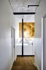 Modern home with Hallway and Light Hardwood Floor. Floating upper cabinets supported by blackened steel posts create a visual buffer between the front public areas and back private zone. Photo 7 of Crosby Loft