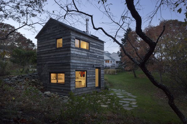 The reclaimed hickory facade of the Micro Cabin by BC-OA is punctured by windows that overlook National Forest Service land.