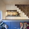Modern home with Kitchen, Undermount Sink, Refrigerator, Wood Backsplashe, Cooktops, Wood Cabinet, Ceiling Lighting, and Stone Counter. A micro kitchen tucked in under the open stair, with operable cabinets functioning as stair treads. Photo 3 of Micro Cabin