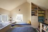 Modern home with Bedroom, Plywood Floor, Bench, Bed, Shelves, and Wall Lighting. The open bedroom at the second floor with built-in desk and shelving. The double height space at image left contains netting which supports the body, providing a spot for a floating perch above the entry. Photo 4 of Micro Cabin