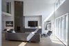 Modern home with Living Room, Recliner, Sectional, Floor Lighting, Lamps, Coffee Tables, Track Lighting, Table Lighting, Gas Burning Fireplace, Light Hardwood Floor, Chair, Media Cabinet, and Ottomans. Main Living Area Photo 6 of Indian Hill Residence