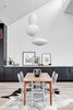 Modern home with Dining Room, Medium Hardwood Floor, Ceiling Lighting, Accent Lighting, Storage, Table, Chair, Pendant Lighting, and Rug Floor. <span style="font-family: Theinhardt, -apple-system, BlinkMacSystemFont, "Segoe UI", Roboto, Oxygen-Sans, Ubuntu, Cantarell, "Helvetica Neue", sans-serif;">Platte Architecture + Design ensured that the family's art and heirlooms would be the center of attention by using a cohesive palette of wide-plank wood floors, crisp white walls, and black accents throughout Pleasant St. Urban Abode.</span> Photo 12 of Pleasant St. Urban Abode
