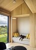 Schiller Projects designed and built many of the Chilmark House's freestanding furniture pieces. In the living area, the family dog reclines on an upholstered bench. Photo 11 of Chilmark House modern home
