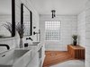 Modern home with Porcelain Tile Floor and Drop In Sink. The master shower features an Ipe shower floor/bench and the vanity has cabinetry by Lignum Cabinets with custom open shelving that extends into the shower. Photo 16 of Details