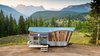 Modern home with Exterior, Wood Siding Material, Metal Roof Material, Shed RoofLine, Camper Building Type, Tiny Home Building Type, Metal Siding Material, and Curved RoofLine. High in the Colorado mountains, this completely off-grid home cleverly fuses art and functionality. Home to a young couple and their two dogs, the eye-catching dwelling showcases the impeccable craftsmanship and creative flair of its occupants. Greg and Stephanie Parham built San Juan Tiny House to include a wavy roof, an angled front prowl, barn wood siding arranged like the rays of the sun, blue ombré shakes on the rear wall, reclaimed materials throughout, and a collapsible front porch, which features a fold-up deck and fold-down awning. On the inside, clever solutions maximize square feet and storage. Photo of The San Juan Tiny House