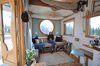 Modern home with Living Room, Coffee Tables, Sofa, Accent Lighting, Medium Hardwood Floor, and Ceiling Lighting. The living area is under the sleeping loft, which is actually an elevator bed. Note the pulley on the right side. Photo 4 of The San Juan Tiny House