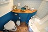 Modern home with Bath Room, Wall Lighting, Wood Counter, Soaking Tub, Freestanding Tub, Vessel Sink, Accent Lighting, Ceiling Lighting, One Piece Toilet, and Glass Tile Wall. The bathroom, which features a penny-tile floor, is relatively large—and even holds a soaking tub. Photo 10 of The San Juan Tiny House