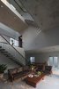 Modern home with Living Room, Ceramic Tile Floor, Ceiling Lighting, and Sofa. The whole house is a brick and concrete three-storey block, with a large central space in the middle of which is a common area for family activities such as living room, reading room, exercise room, etc... Photo 3 of Ninh Binh House