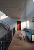 Modern home with Living Room, Ceiling Lighting, Medium Hardwood Floor, Sofa, and Coffee Tables. Inside, the corridors both create a space that connects people and nature, as well as the place where the daily activities of the family take place. Photo 6 of Ninh Binh House