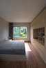 Modern home with Ceiling Lighting and Medium Hardwood Floor. HGAA ensured that all the rooms of the home have a direct view of nature. The windows in the bedroom of the Ninh Binh House provide light and ventilation, while the outside greenery helps create the privacy needed for the interior space. Photo 13 of Ninh Binh House