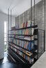 Neuman Heyner designed every inch of the home to work in tandem; the staircase contains a bookcase that doubles as a balustrade. Photo 5 of the house by the dunes modern home