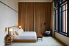 Modern home with Bedroom, Floor Lighting, Bed, Rug Floor, Wall Lighting, Medium Hardwood Floor, Night Stands, Chair, Lamps, and Bench. Throughout, Gachot Studios aimed for a homey, simple approach to design.
Photo 5 of The Shinola Hotel