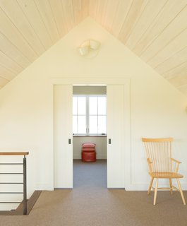 The loft melds a walnut perimeter with soft carpeting underfoot.