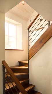 Thick slabs of walnut serve as treading on the staircase.