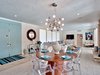 Modern home with Dining Room, Recessed Lighting, Light Hardwood Floor, Pendant Lighting, Storage, Chair, Table, Marble Floor, and Rug Floor. Sky blue doors open onto the intimate dining table, accentuated by transparent seating and dramatic lighting. Photo 2 of Arnaz-Ball Residence