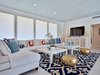 Modern home with Living Room, Console Tables, Coffee Tables, Light Hardwood Floor, Rug Floor, Ottomans, Recessed Lighting, Sectional, and Media Cabinet. Gold poufs in the living area are among the home's post-renovation accents. Photo 4 of Arnaz-Ball Residence