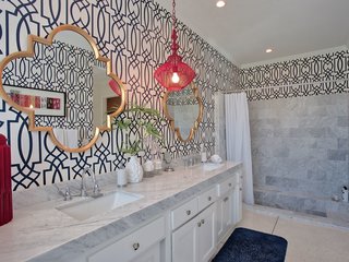 Bold wallpaper in the bathroom continues the home’s vibrant character.