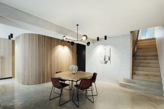 Emphasizing the interior's verticality and curves are the timber walls and screens that enhance spatial flow and light.