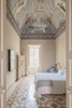 Modern home with Bedroom, Bed, Porcelain Tile Floor, Wall Lighting, Chair, and Night Stands. A ceiling fresco and mosaic floor steal the limelight in the Royal Junior suite. Photo 10 of Palazzo Daniele