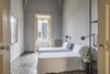 Modern home with Bedroom, Wall Lighting, Porcelain Tile Floor, and Bed. "The walls are all done up with local finishes, painted with lime and various pigments from the region," says Gabriele Salini, Palazzo Daniele's co-owner. Photo 8 of Palazzo Daniele