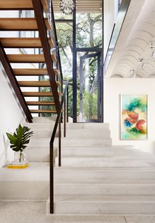 An open-plan staircase leads to a hushed sleeping area above.