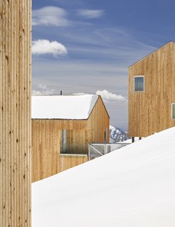 Some cabins follow the mountain's contours while a cross-grain version juts out over the blanket of snow.