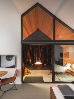 Through the full-height wall of windows, views of the outdoors can be savored from the bedroom.