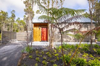 A cheerful red door welcomes guests to the cedar-sided cabin.