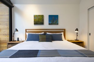 Done up in blue, the bedroom is accentuated by local artwork.