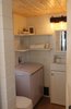 Modern home with Laminate Floor. The bathroom features extra storage, a small vanity cabinet and sink, and the Separette compost toilet. An extreme weather cat door is also located in the bathroom and provides easy access to the litter box located inside the storage shed. Photo 11 of Innisfree Anarres
