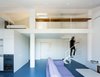 Modern home with Living Room, Coffee Tables, and Sofa. The second level of Loft 01 by Nada is reached by climbing a light, circular staircase. The loft was envisioned as an "open integrated space," between the two floors. Photo of Loft 01