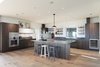Modern home with Kitchen, Wood Cabinet, Stone Counter, Dishwasher, Wall Oven, Stone Slab Backsplashe, Refrigerator, Medium Hardwood Floor, Cooktops, Recessed Lighting, Undermount Sink, Wine Cooler, Concrete Floor, Pendant Lighting, and Ceiling Lighting. Kitchen by HenryBuilt Photo of 2 Barns