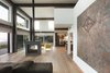 Modern home with Living Room, Two-Sided Fireplace, Gas Burning Fireplace, Sofa, Medium Hardwood Floor, Chair, and Pendant Lighting. The living area of 2 Barns features a doubled-sided fireplace, hardwood floors, and a neutral color palette. Architect Barry Price prized utilizing local materials in the ADA-accessible home. Photo 2 of 2 Barns