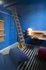 Modern home with Light Hardwood Floor and Chair. Wooden moveable ladder and POI system in the blue room Photo 16 of Blue and concrete apartment