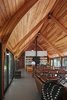 Modern home with Living Room, Sofa, Chair, Ceiling Lighting, Storage, and Concrete Floor. “Sharing roots with local Michiana pole barns, this economical structure of glue-laminated Douglas fir bents, braces, and decking is held above runoff and snow by galvanized steel stirrups,” says Wheeler Kearns Architects. The boat-like, wooden ceiling in Bohan Kemp is a truly unique feature, directing air flow and adding charm to the space. Photo 5 of Bohan Kemp