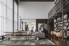 Modern home with Living Room, Bookcase, and Dark Hardwood Floor. A full penthouse floor of a Chicago high-rise with 11-foot ceilings was gutted by Wheeler Kearns Architects to make way for the vision of two life-long collectors. They wanted a space that would display their furnishings ranging from midcentury to contemporary pieces as well as an array of art and sculptures. In addition to comfortably housing the couple and their dog, the home also needed to be able to transition into an event space that could accommodate 75 people. Photo 3 of Residence for Two Collectors