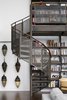 Modern home with Staircase, Metal Railing, Wood Railing, and Metal Tread. Wheeler Kearns Architects used steel to construct the shelving, storage, and stairs leading up to the mezzanine loft in the Residence for Two Collectors. The client’s father was a machinist, so the fabrication of these elements lends a personal touch to the project. Photo 7 of Residence for Two Collectors