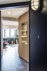 Modern home with Hallway and Slate Floor. Entry area- a shoe storage with wood slat panels and a brass punch out to frame the view into the kitchen Photo 2 of Quarry Bay Residence