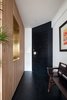 Modern home with Hallway and Slate Floor. Entry area- a shoe storage with wood slat panels and a brass punch out to frame the view into the kitchen Photo 3 of Quarry Bay Residence