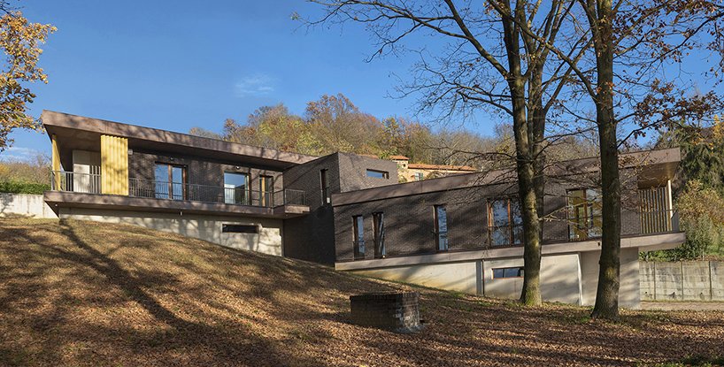 Two elongated volumes pivot around the cubic volume of the common staircase