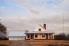 Modern home with Exterior, Wood Siding Material, Gable RoofLine, House Building Type, and Metal Roof Material. After passing through a small grove of trees at the front of the property, the drive turns toward the front view of the farmhouse. Photo of OKC Farmhouse